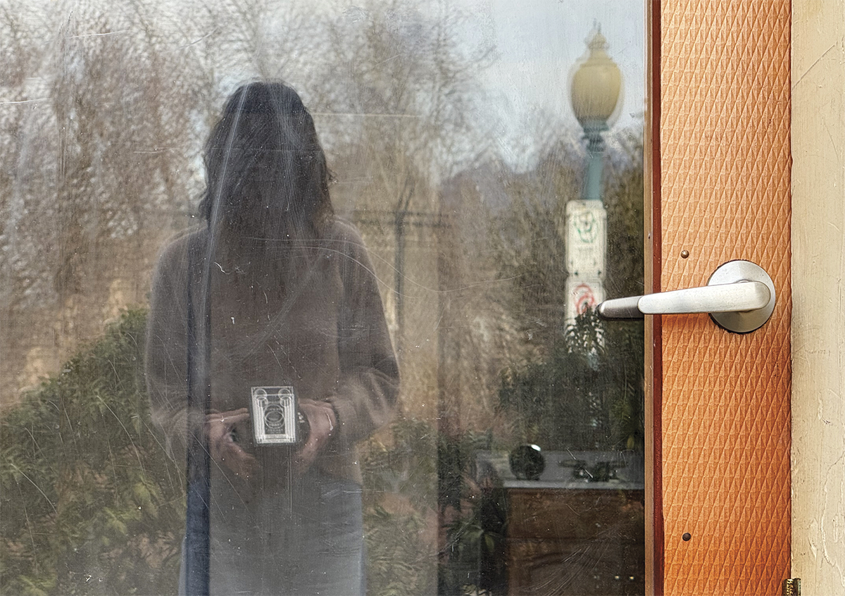 reflection of vintage camera and photographer in window